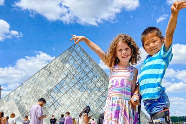 Kids posing with the Louvre during summer vacation