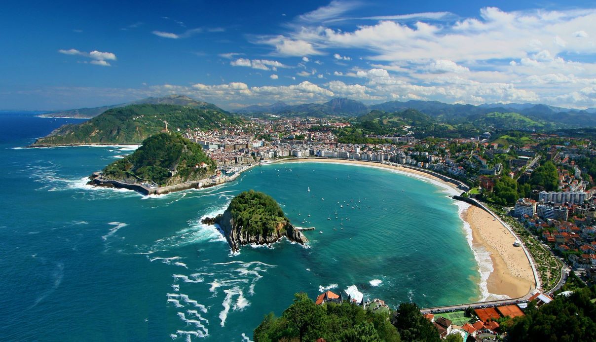 Horseshoe-shaped beach in San Sebastian, with an island in the middle of the bay.