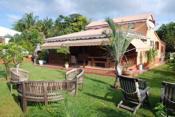 Jolie maison colorée, en bois sous le soleil des Antilles contre une maison à la campagne ou la montagne